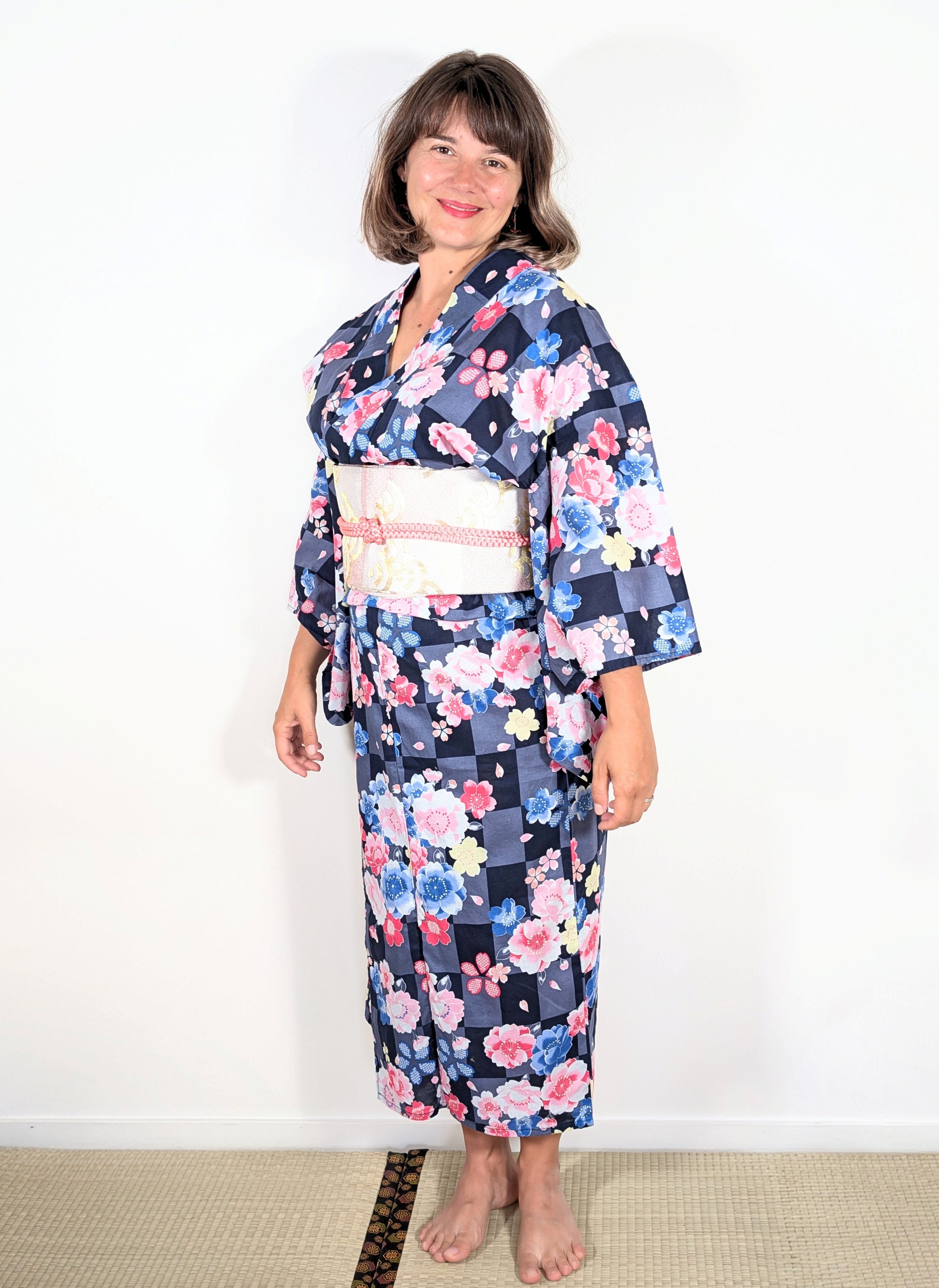Yukata japonais femme en coton avec motif sakura sur damier ichimatsu gris et noir, porté avec obi clair
