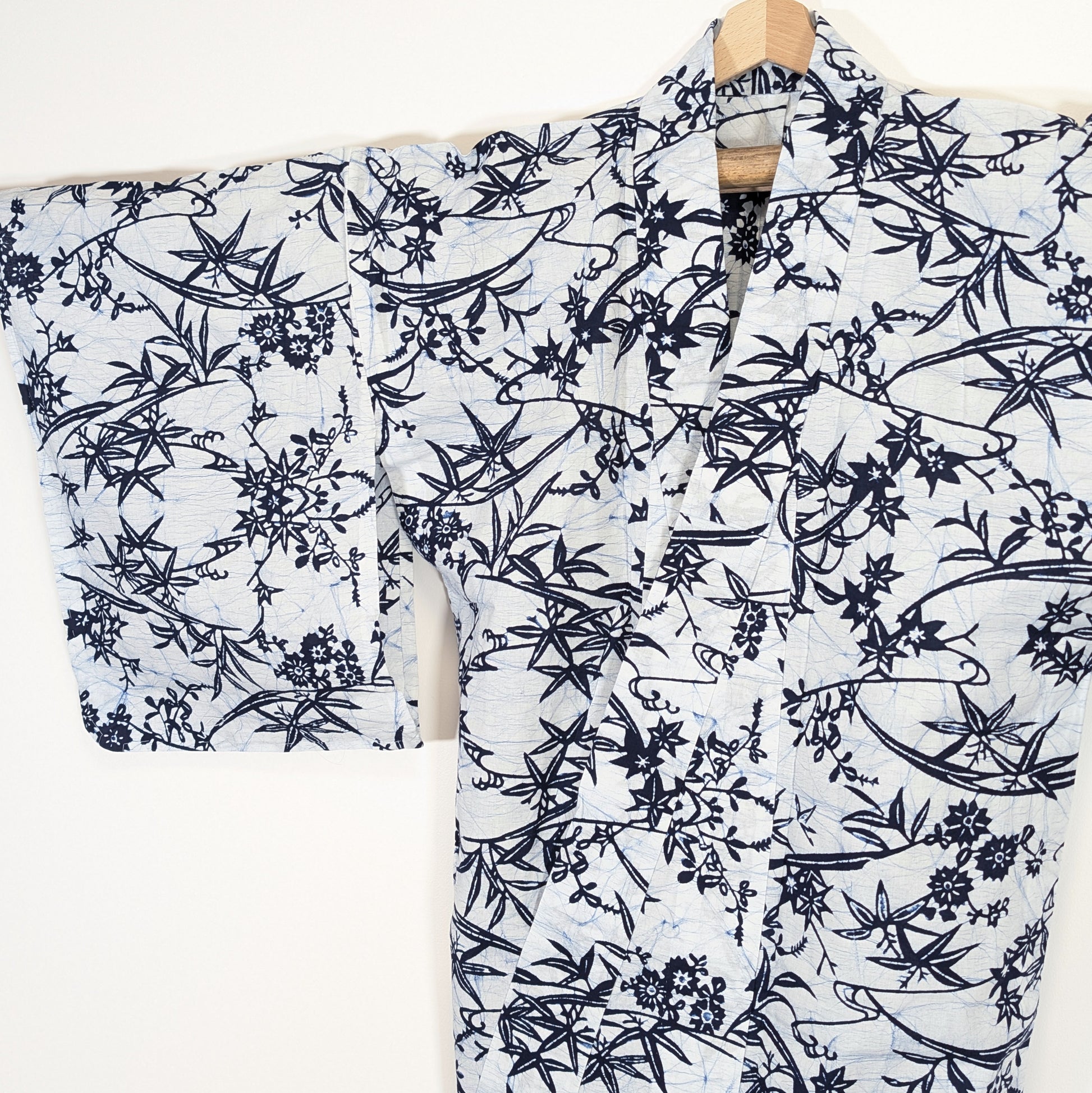Détail des manches larges d’un yukata traditionnel japonais avec motifs momiji, sasa no ha et fleurs bleues