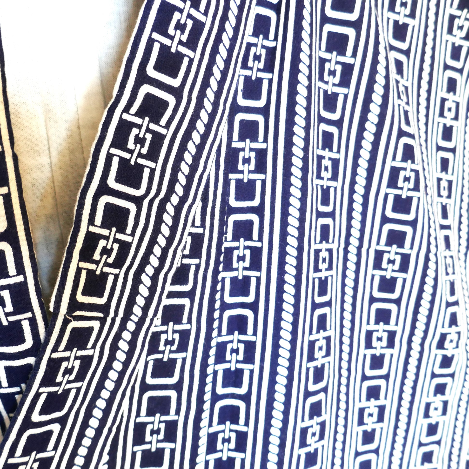 Gros plan sur le motif entrelacé du yukata, représentant des chaînes stylisées