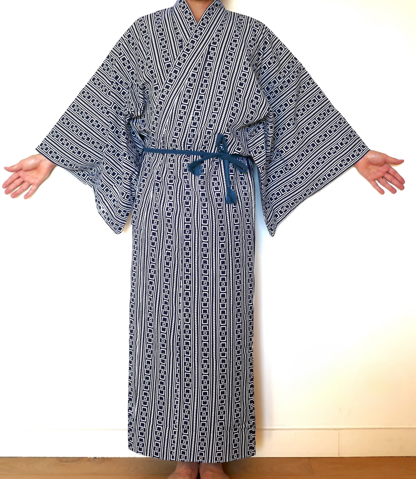 Yukata à motif yoshiwara tsunagi revisité porté, ceinturé avec une obi-jime bleue, bras ouverts
