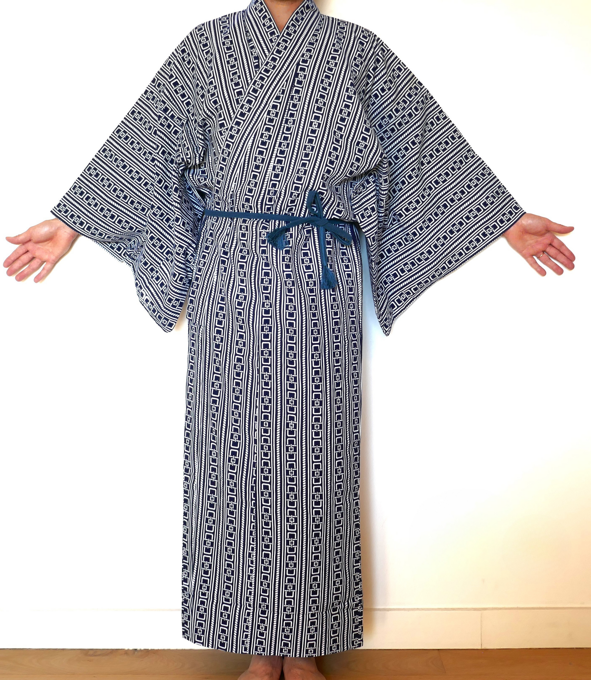 Yukata à motif yoshiwara tsunagi revisité porté, ceinturé avec une obi-jime bleue, bras ouverts