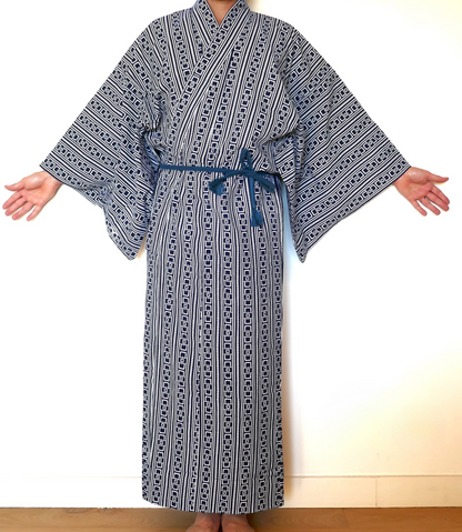 Yukata à motif yoshiwara tsunagi revisité porté, ceinturé avec une obi-jime bleue, bras ouverts