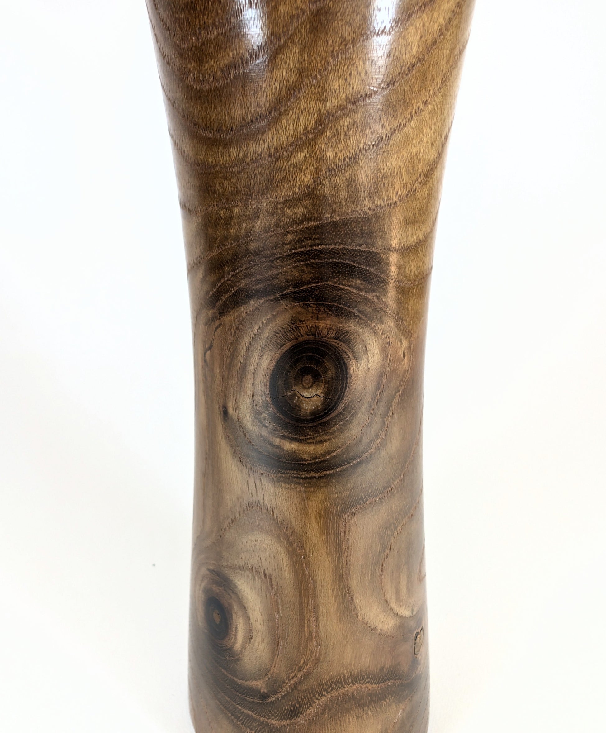 Détail du bois sculpté d'une kokeshi traditionnelle, nœuds apparents et veinage naturel