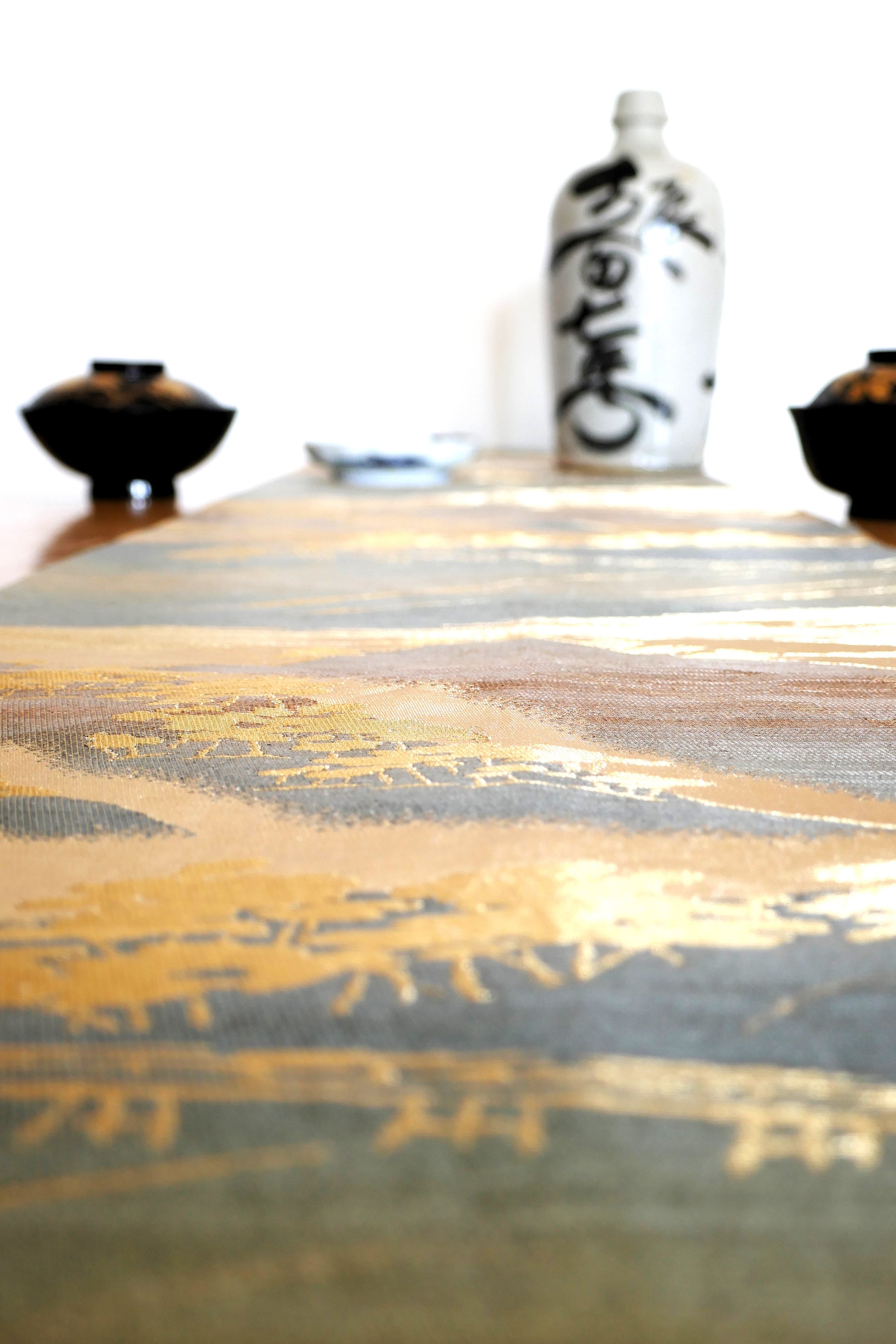 zoom sur les reflets dorés et métalisés du fukuro obi fuji posé sur table